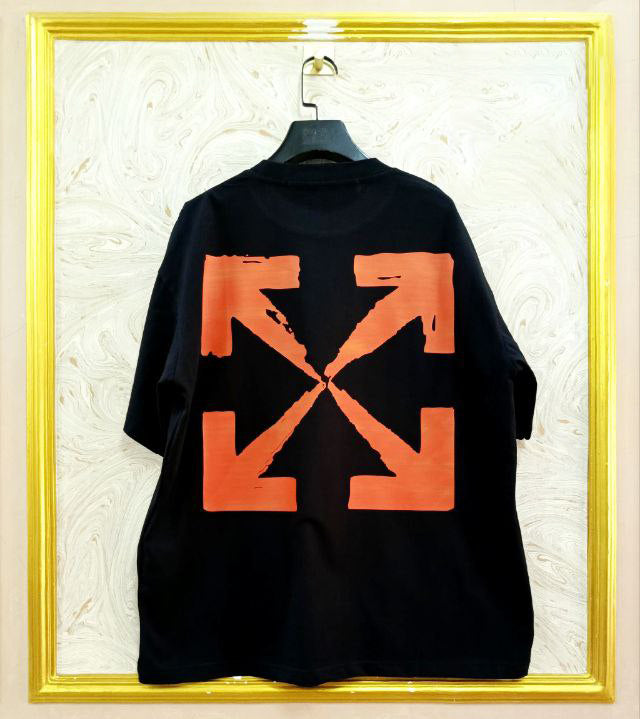 Black t-shirt with "Off-White™" design on a hanger against a decorative wall.