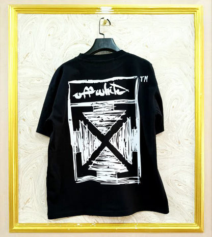 Black t-shirt with "Off-White™" design on a hanger against a decorative wall.