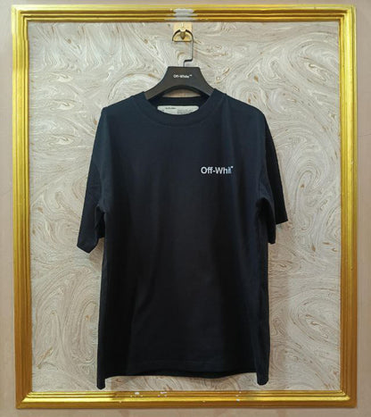 Black t-shirt with "Off-White™" design on a hanger against a decorative wall.