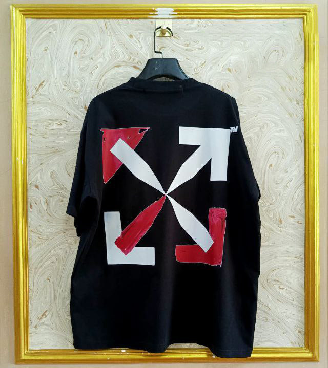 Black t-shirt with "Off-White™" design on a hanger against a decorative wall.