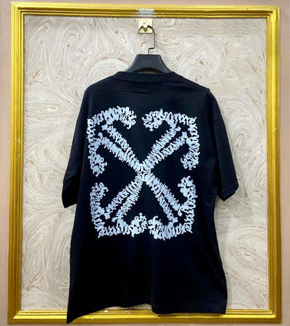 Black t-shirt with "Off-White™" design on a hanger against a decorative wall.