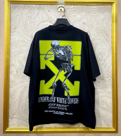 Black t-shirt with "Off-White™" design on a hanger against a decorative wall.