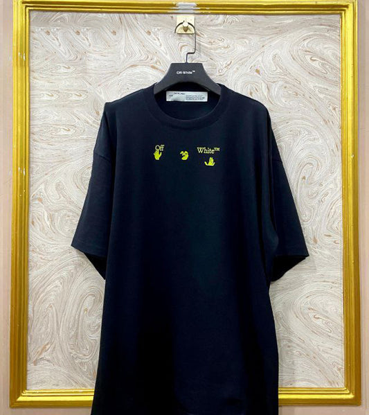 Black t-shirt with "Off-White™" logo on a hanger against a marble wall.