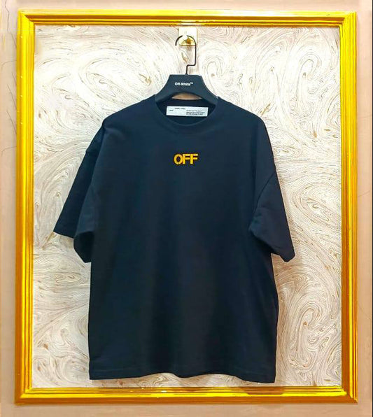 Black t-shirt with 'OFF' logo on a hanger against a decorative wall.