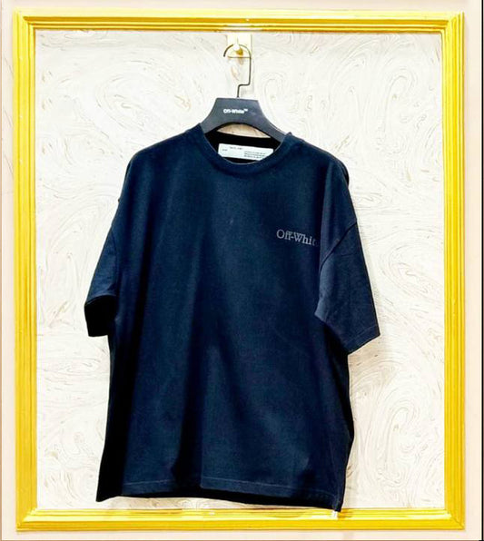 Navy blue t-shirt with 'Off-White' logo on a hanger against a textured white wall.