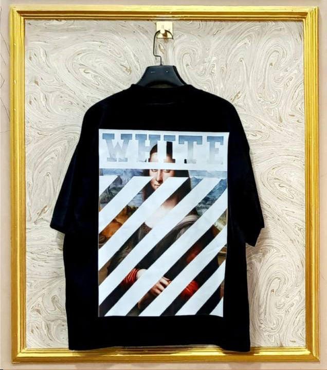 Black t-shirt with graphic design on a textured wall with gold frame