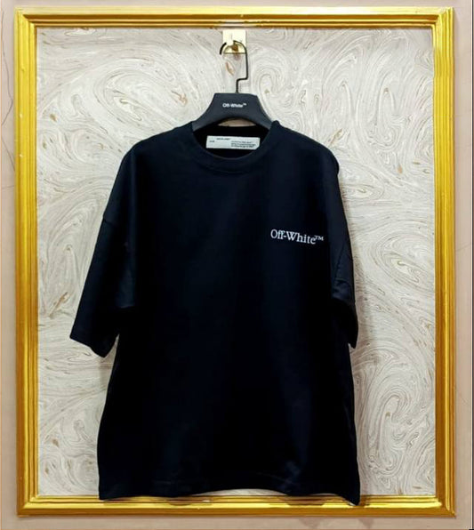 Black t-shirt with 'Off-White' logo on a hanger against a marble wall.
