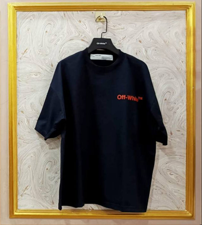 Black t-shirt with red "Off-White™" logo on a hanger against a marble wall.