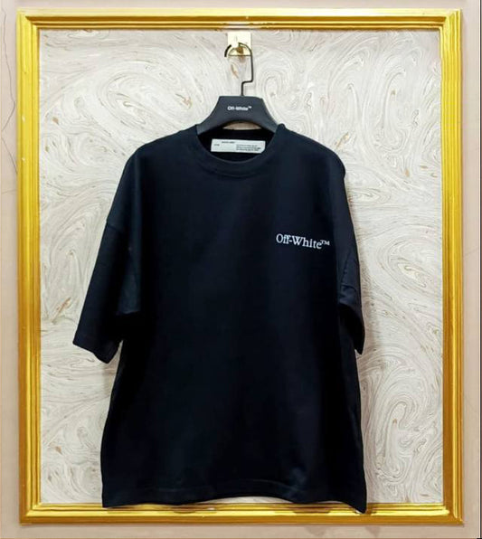 Black t-shirt with 'Off-White' logo on a hanger against a textured wall.