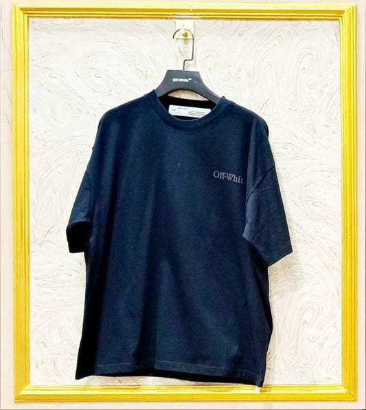 Navy blue t-shirt with 'OFF-WHITE' logo on a hanger against a textured white wall.