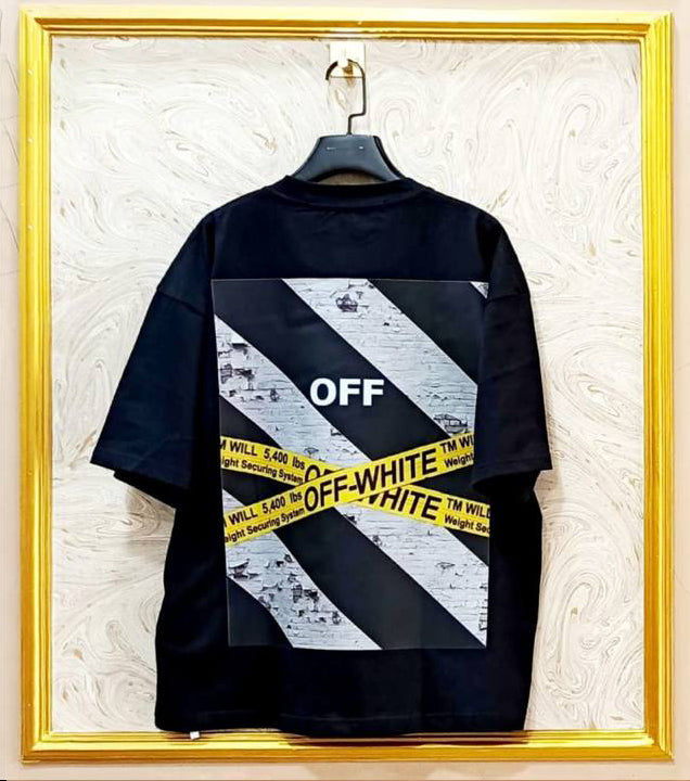 Back view of black oversized t-shirt inspired by Off-White with white diagonal stripes, “OFF” text, and yellow industrial belt graphic crossing the print.