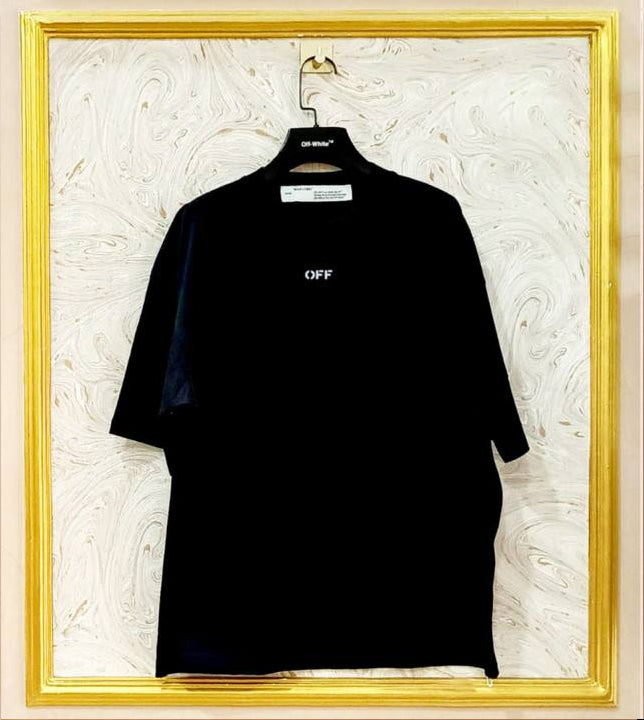 Black oversized t-shirt inspired by Off-White with “OFF” front logo, displayed on hanger in gold frame.