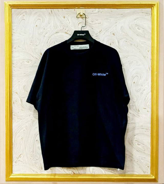 Black t-shirt with 'Off-White' logo on a hanger against a textured white wall.