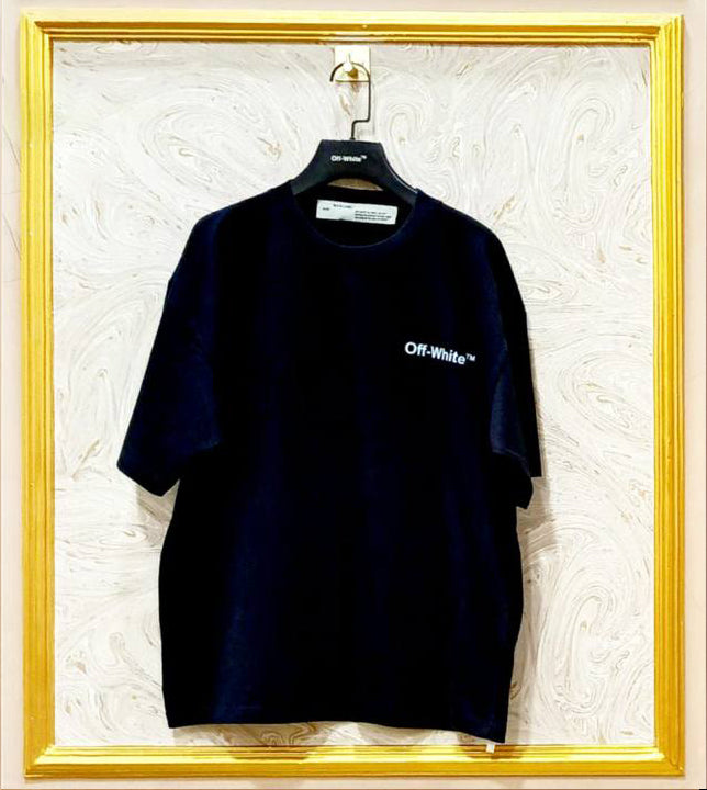 Black t-shirt with 'Off-White' logo on a hanger against a textured white wall.