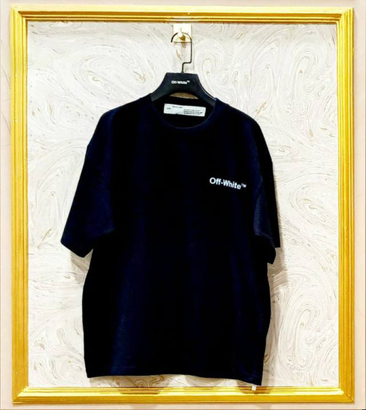 Black t-shirt with 'Off-White' logo on a hanger against a textured white wall.