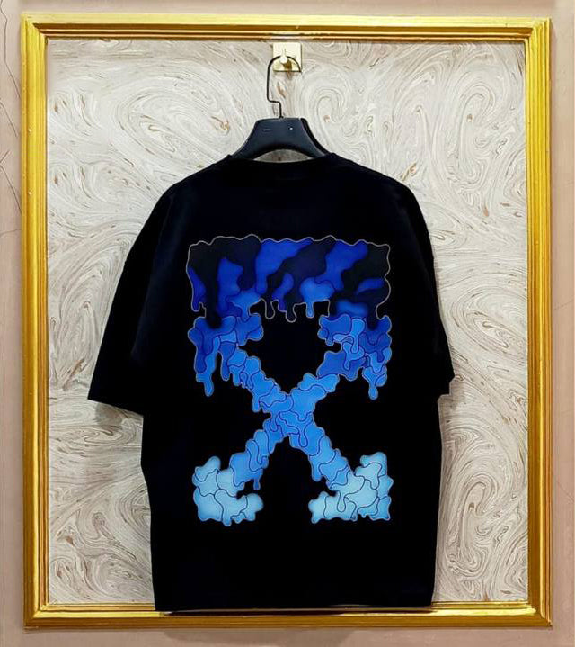 Black t-shirt with flag "Off-White™" design on a hanger against a decorative wall