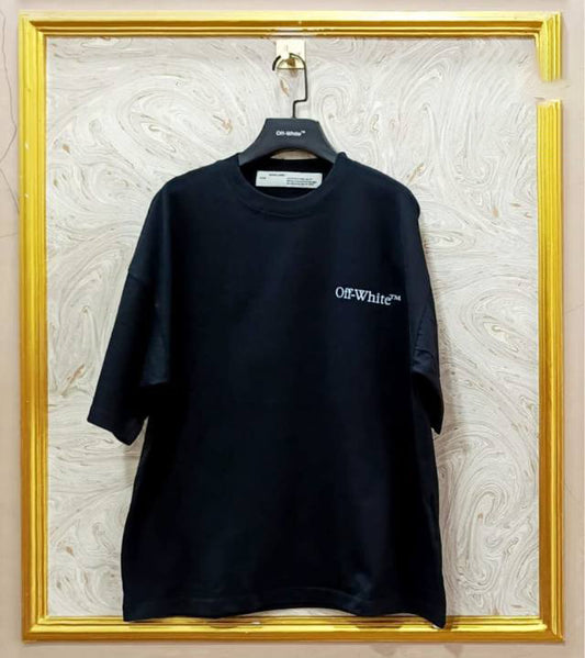 Black t-shirt with "Off-White™" logo on a hanger against a marble wall.