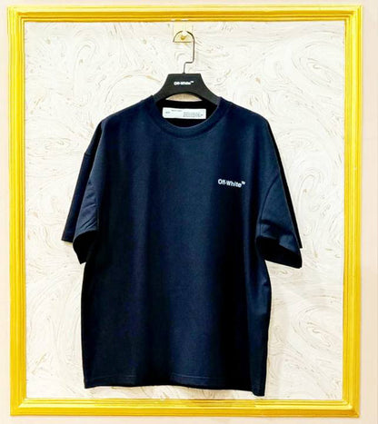 Black t-shirt with "Off-White™" logo on a hanger against a marble wall.