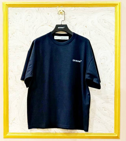 Black t-shirt with "Off-White™" logo on a hanger against a marble wall.