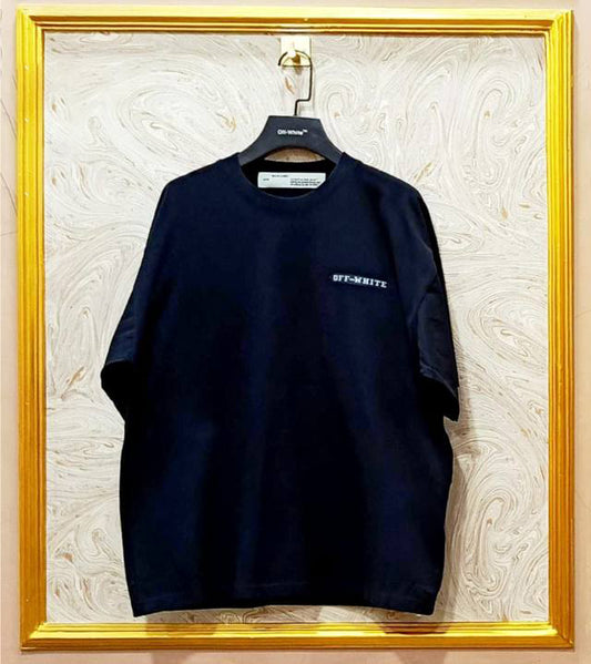 Black t-shirt with "Off-White™" logo on a hanger against a marble wall.