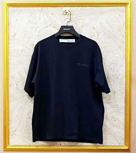 Black t-shirt with "Off-White™" logo on a hanger against a marble wall.