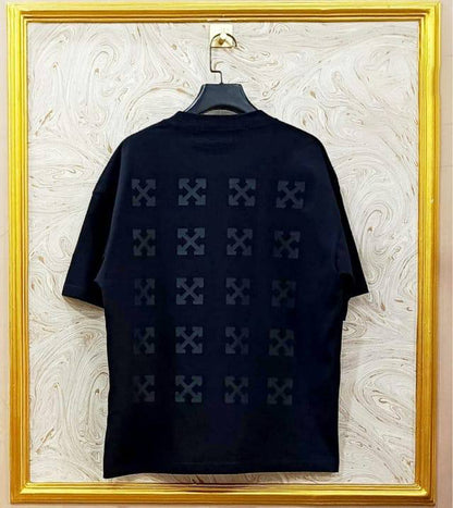 Black t-shirt with "Off-White™" design on a hanger against a decorative wall.
