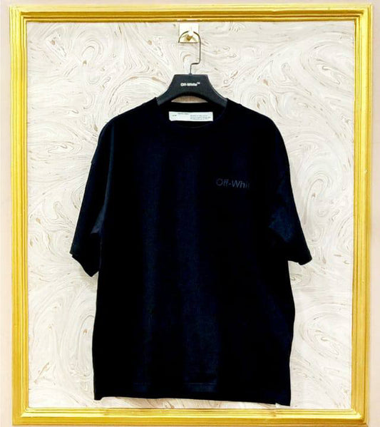 Black t-shirt with "Off-White™" logo on a hanger against a marble wall.