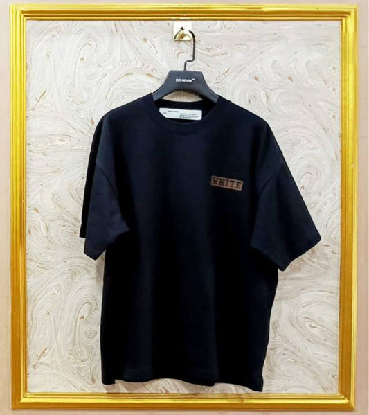 Black t-shirt with "Off-White™" logo on a hanger against a marble wall.