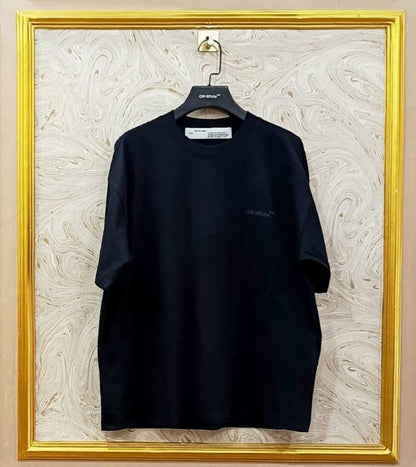 Black t-shirt with "Off-White™" logo on a hanger against a marble wall.