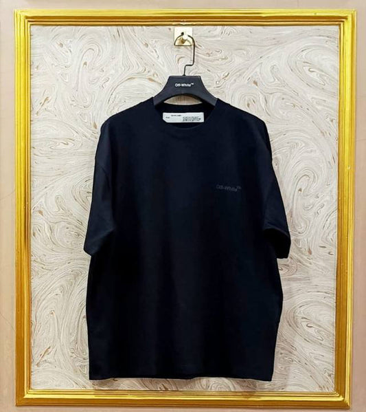 Black t-shirt with "Off-White™" logo on a hanger against a marble wall.