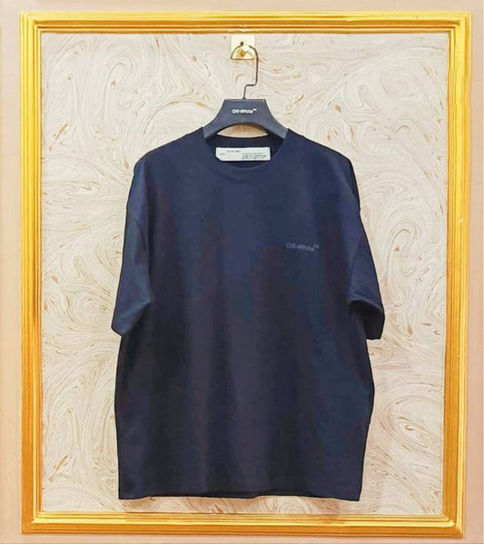 Black t-shirt with "Off-White™" logo on a hanger against a marble wall.